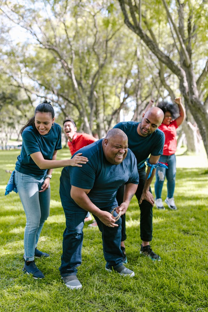 Group of People Playing on Green Grass Field